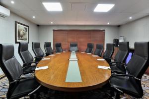 a conference room with a large wooden table and chairs at Kwa Maritane Lodge in Ledig