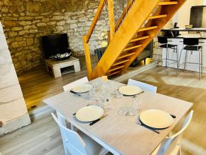 a table with white plates and wine glasses on it at Charme unique sous les remparts in Châteauneuf-de-Gadagne +8 photos