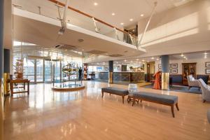 a lobby of a building with benches and tables at The Portswood Hotel in Cape Town