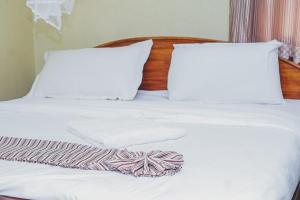 Postel nebo postele na pokoji v ubytování kapok city hotel