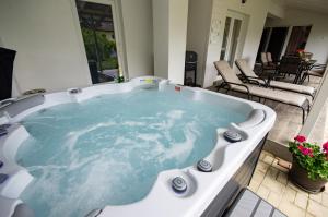 a jacuzzi tub on a patio with chairs at Boutique Villa Gyula in Gyula