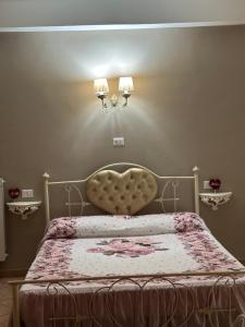 sypialnia z łóżkiem z dużym wezgłowiem i dwoma lampami w obiekcie B&B la reggia w mieście Caserta
