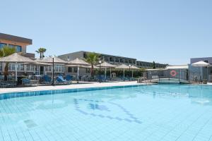 a large swimming pool with chairs and umbrellas at Kalia Beach in Gouves