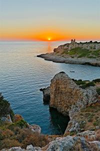 a sunset over the ocean with a rocky coastline at Villa Cenate in Nardò +16 photos