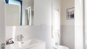 a white bathroom with a sink and a mirror at Baia Petrea - 2 Nuovissime Suite in Marina Centro in Rimini