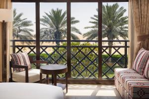 a room with a large window with palm trees at Aldhafra Resort, Vignette Collection by IHG in Madīnat Zāyid