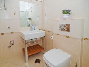 a bathroom with a white sink and a toilet at Lavender Suite Zadar in Zadar