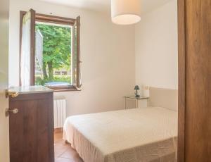 un dormitorio con una cama y una ventana en Casa Carla, en Massa