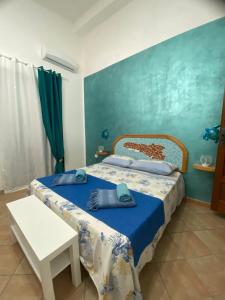 a bedroom with a bed with a blue wall at L’Olimpo sul mare in Lampedusa +7 photos