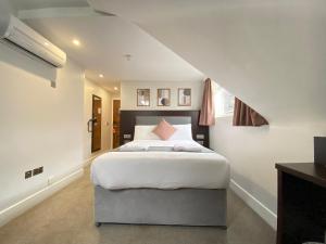 a bedroom with a large white bed with a staircase at Trebovir Hotel in London