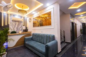 a waiting room with a blue couch in a lobby at Hotel RD Palace in Agra