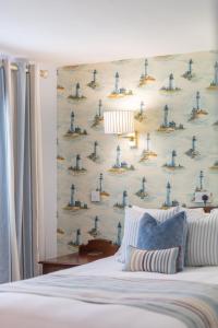 a bedroom with a wall with a blue and white wallpaper at Roman Camp Inn in Aylmerton
