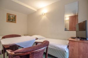 a hotel room with two beds and a tv at Willa Koron a Mielno in Mielno +18 photos