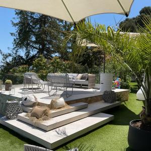 a patio with a couch and chairs and an umbrella at Luxury villa Panoramic Sea View Near Monaco in Éze