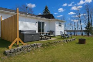 a backyard with a barbecue and a table and chairs at Condo 1 - Waterfront with SPA Fireplace & Barbecue in Sainte-Anne-de-Beaupré +35 photos