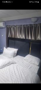 a bed with white sheets and pillows in a room at promise hotel gbagada in Lagos