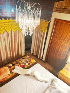 a chandelier is hanging over a bed in a room at Pousada Tarumã challes 3 in Bonito