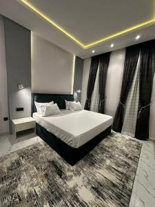 a bedroom with a large white bed with a rug at promise hotel gbagada in Lagos