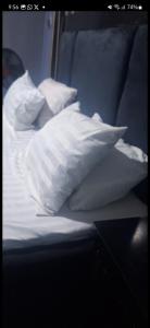 a bed with white sheets and pillows on it at promise hotel gbagada in Lagos