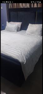 a large bed with white sheets and pillows at promise hotel gbagada in Lagos