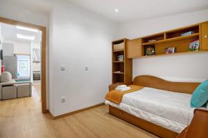 a bedroom with a bed and wooden shelves at Moradia dos Castelos Amarelo in Santarém +27 photos