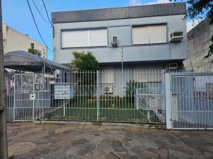 a white fence in front of a house at Consulado Americano Studio 40 mts do Consulado do Estados Unidos in Porto Alegre
