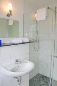 a white bathroom with a sink and a shower at Holiday-2 in Prerow +10 photos