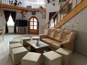 a living room with a couch and a table at Tüskevár Panzió in Abádszalók