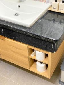 a bathroom sink with a wooden cabinet underneath it at Chiri Homestay in Thôn Trường Giang