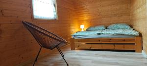 een slaapkamer met een bed in een houten hut bij Domki Milena in Mieroszyno