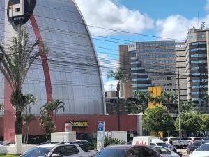 巴西利亚Flat particular no Hotel Grand Mercure com varanda, garagem e wi-fi的建筑物前停放汽车的停车场