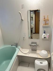 un bagno con vasca, WC e lavandino di 民宿NaMi ad Awara
