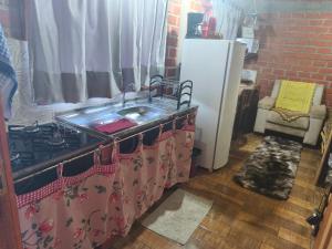 a kitchen with a sink and a refrigerator at Pousada Tarumã challes 3 in Bonito