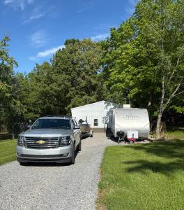 a car parked next to a trailer and a camper at Cozy Camper in Creal Springs