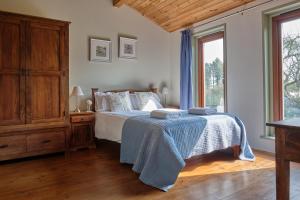 a bedroom with a bed with a blue blanket on it at Middlewick Holiday Cottages in Glastonbury