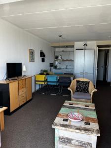 a living room with a table and a kitchen at Zuiderzeestate 28 in Makkum