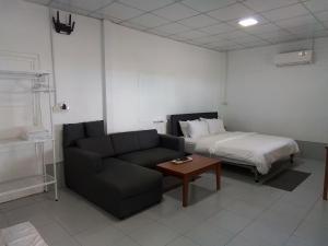 a living room with a couch and a bed at The Rock Coco Villa in Ban Laem Pom