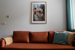 a couch in a living room with a picture on the wall at Apartments Abacie Nový Jičín in Nový Jičín