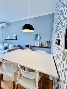 a dining room with a white table and chairs at Departamento Peatonal I in Concordia +7 photos