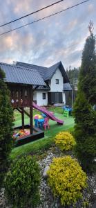 a backyard with a playground with a slide at Domek Sołtysówka Balia&Sauna in Gliczarów Górny