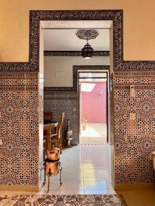 eine offene Tür zu einem Raum mit einem Tisch mit einem Topf in der Unterkunft Apartment with rooftop access in Marrakesch