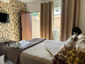 a bedroom with a bed with towels and a window at Espaço Praia - Suíte 101 in Angra dos Reis