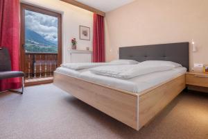 a bedroom with a large bed and a large window at Haus Christine in Rifiano +35 photos