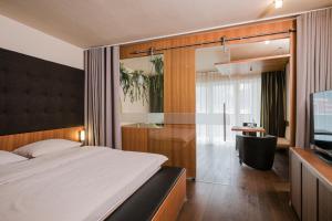 a bedroom with a bed and a desk and a television at Lindenhof Pure Luxury & Spa DolceVita Resort in Naturno +171 photos