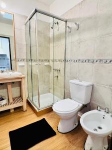 a bathroom with a shower and a toilet and a sink at Departamento Peatonal I in Concordia