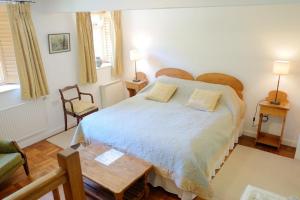 a bedroom with a large bed and a table at Bagnell Farm Cottage in Chiselborough