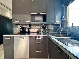 a kitchen with stainless steel cabinets and a sink at Studio Love Room Rooftop Jacuzzi SCLS Rentals in Cannes