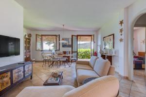 a living room with a couch and a tv at Villino Martini in Marciana