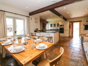 a kitchen and living room with a wooden table and chairs at Burrs Farm in Buxton