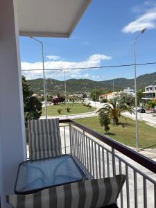 un balcon avec une chaise et une vue sur une rue dans l'établissement Yannos 1930, à Nea Iraklitsa